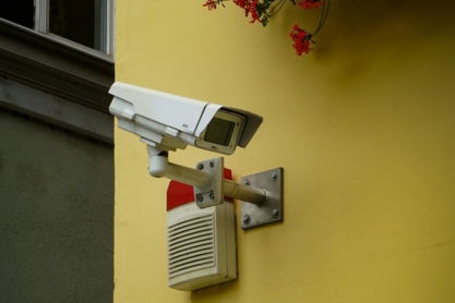 white-and-gray-security-camera-mounted-on-yellow-painted-wall.jpg white and gray security camera mounted on yellow painted wall