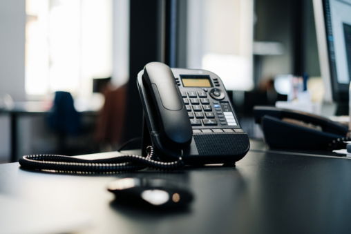 black-ip-desk-phone-on-black-wooden-table.jpg black ip desk phone on black wooden table